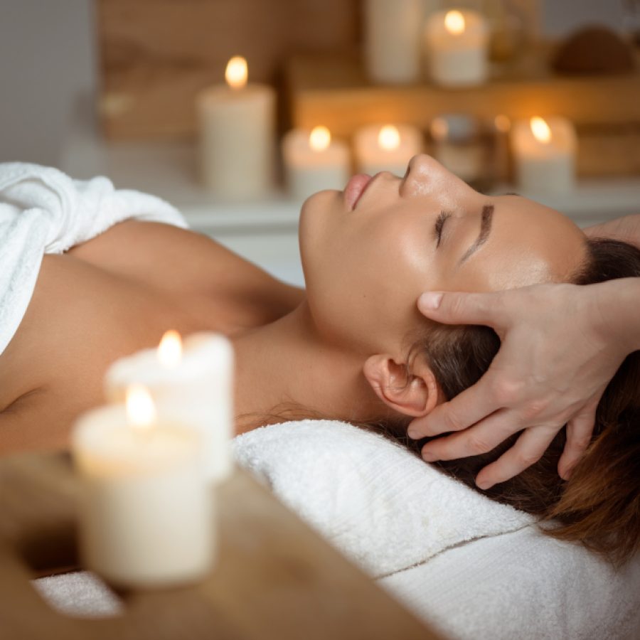 Personne recevant un massage du visage dans une ambiance relaxante.